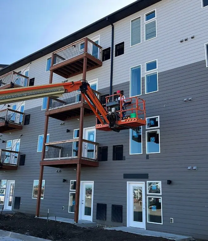 Construction worker working on the siding of an apartment complex