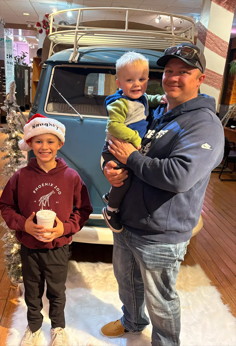 Father posing with his sons in front of a VW Van