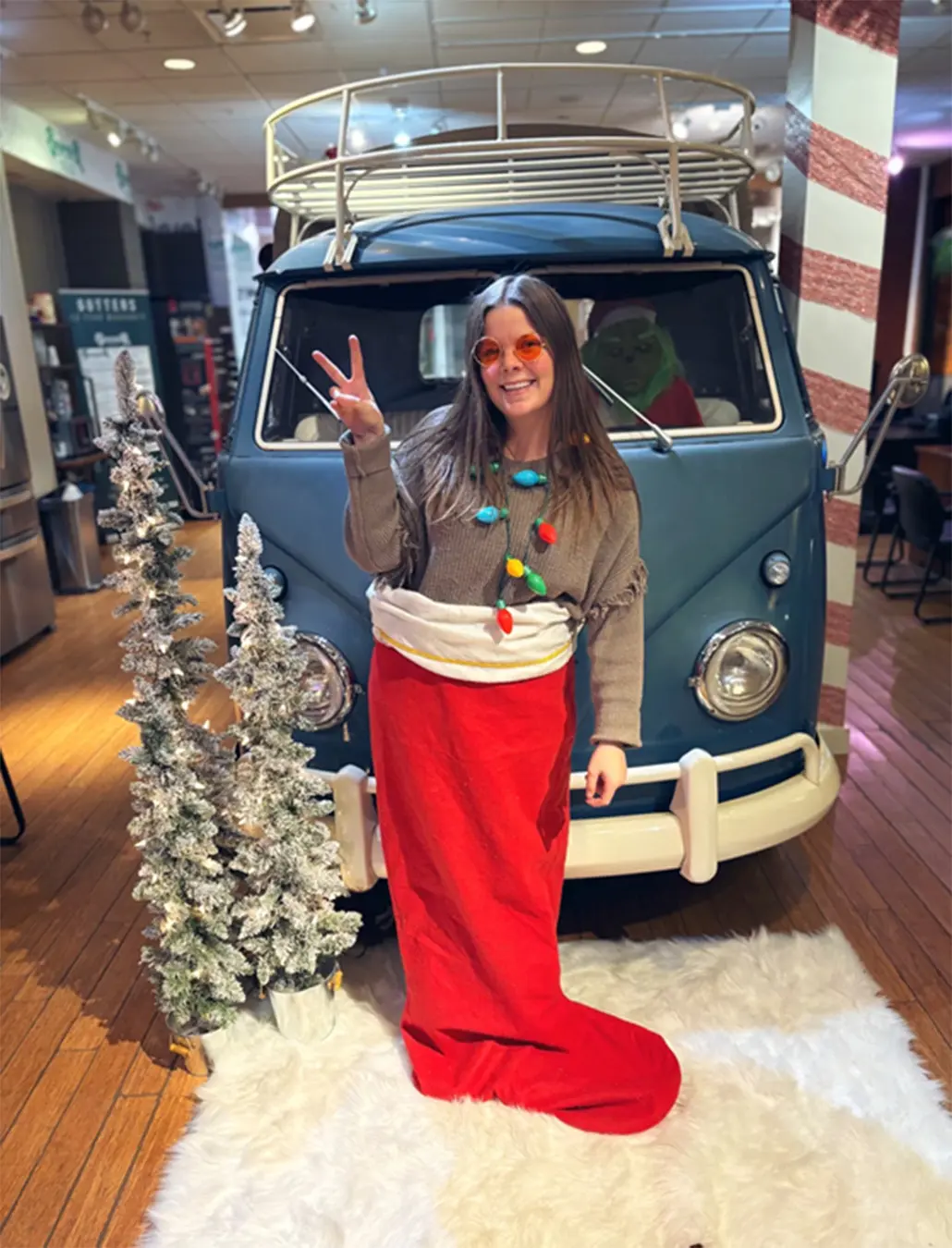 Woman poses in front of VW Van with Hippy Glasses and Giant Stocking