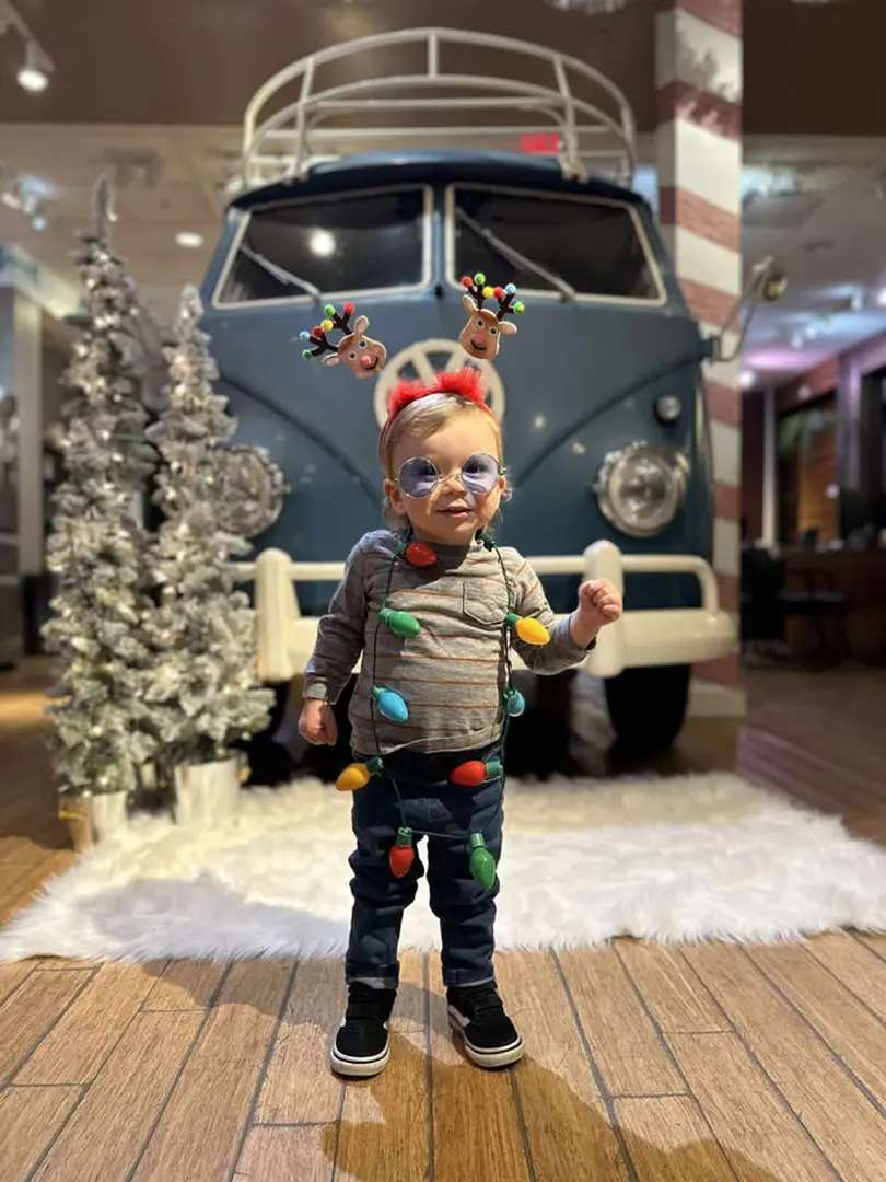 Young kiddo poses in front of festive VW Van