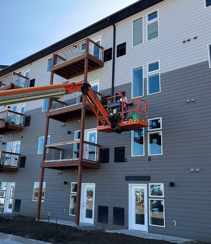 Construction worker working on the siding of an apartment complex