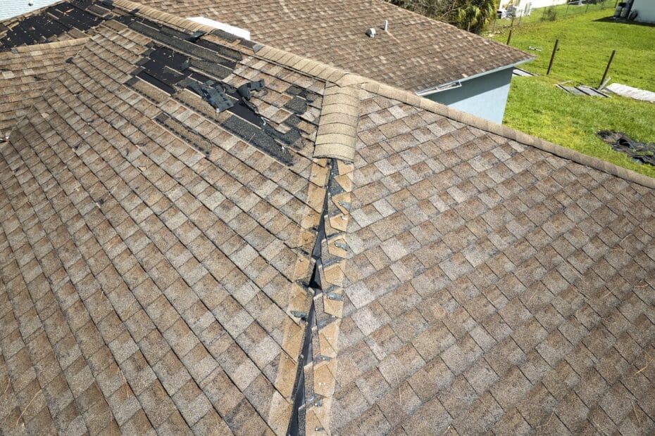 Damaged house roof with missing shingles