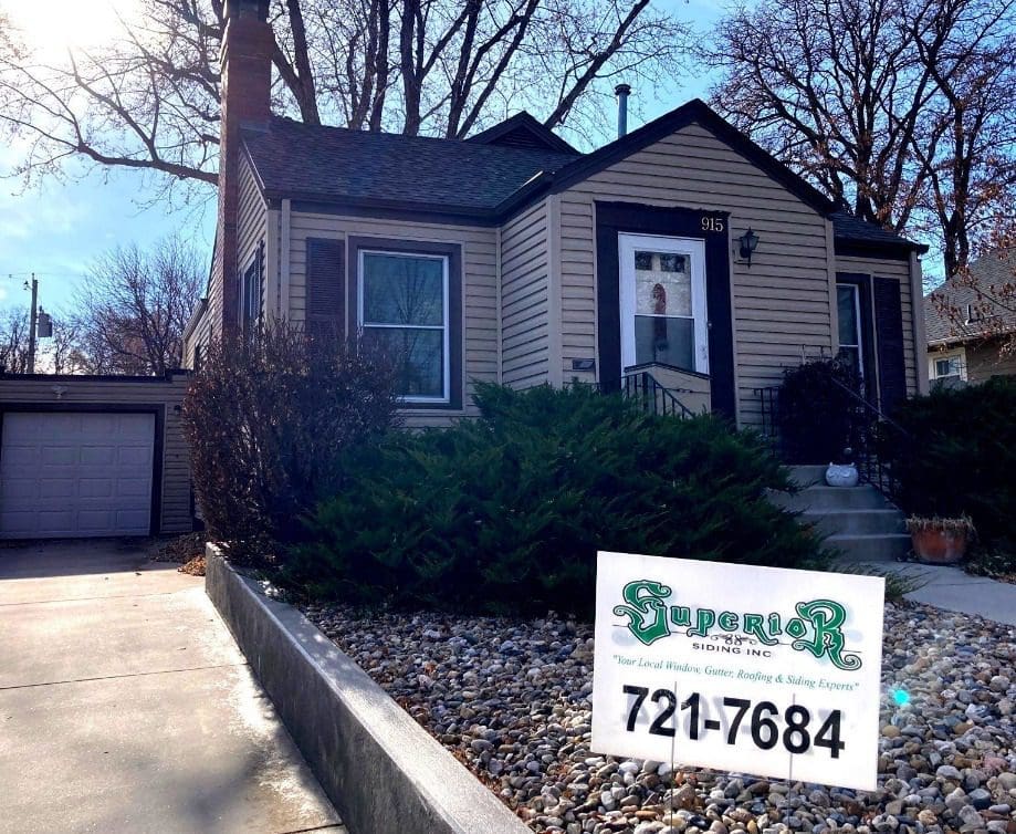 House with new beige siding and Superior Siding sign in the front yard