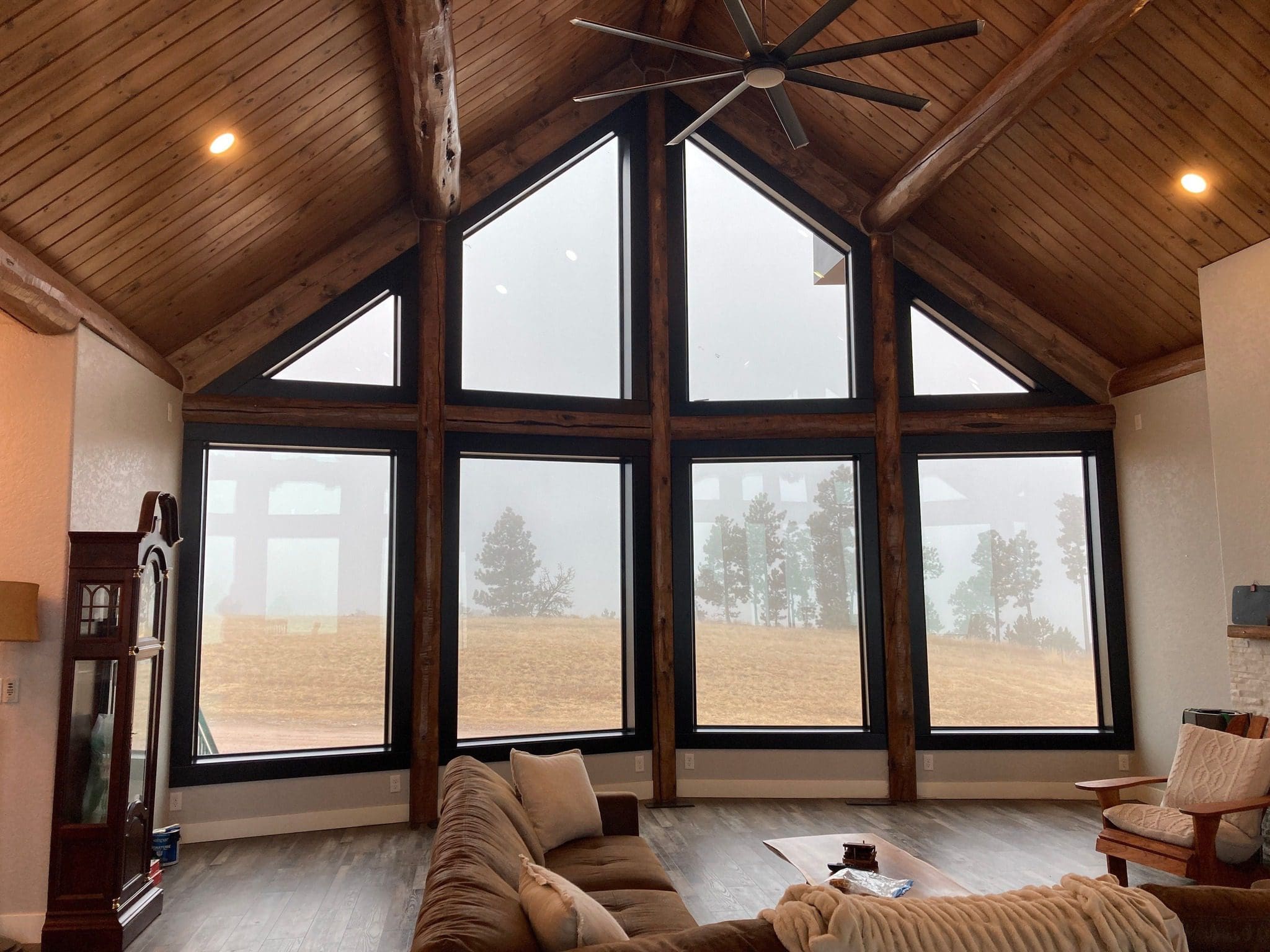 Looking out large windows of a living room to a field