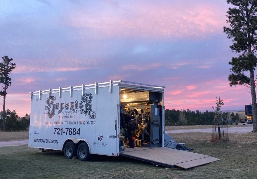 Superior Siding open construction trailer against a sunset