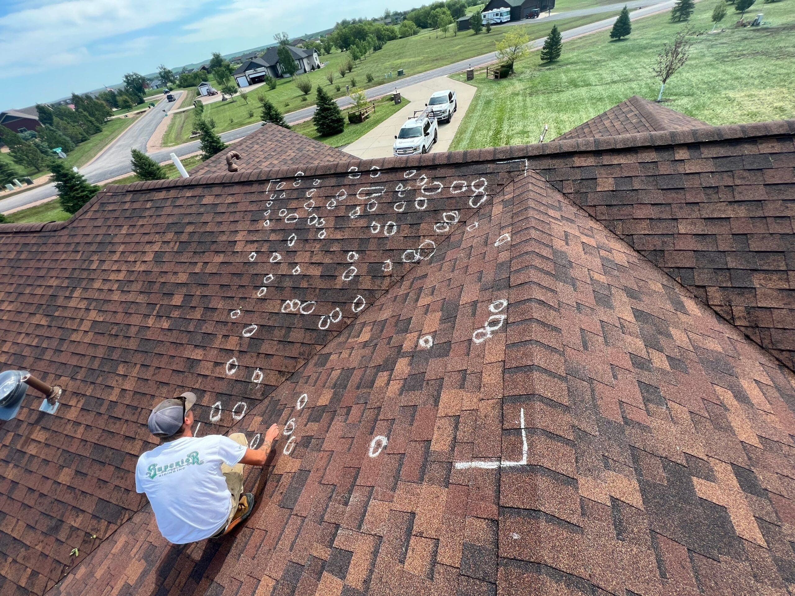 Man marking damages done to a shingled roof