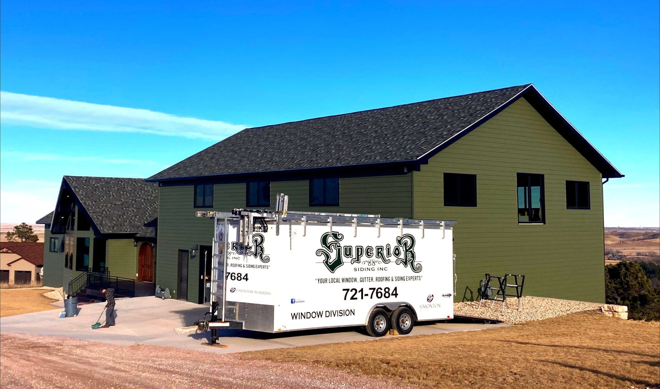 Superior Siding Inc. trailer in front of a home with new green color siding installed