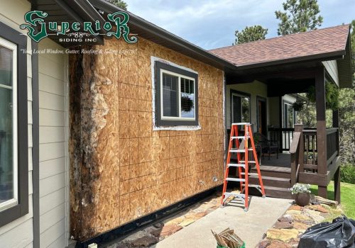 Construction worker installing new siding on a house